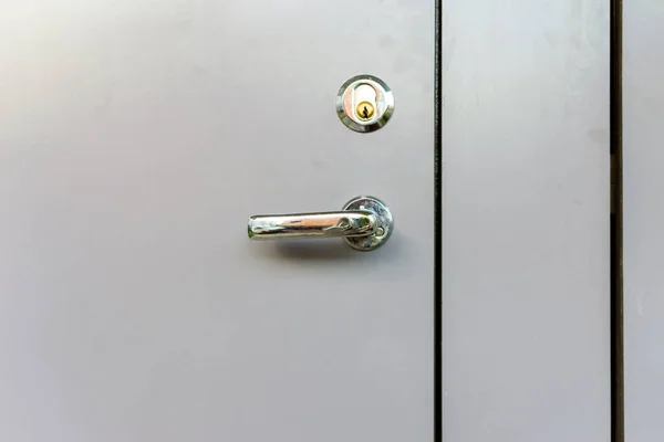 Exterior door handle and Security lock on light gray Metal frame