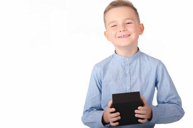 Mavi tişörtlü, gülümseyen beyaz sarışın çocuk siyah kutu tutuyor. Beyaz stüdyo geçmişini ayır.