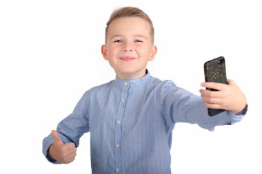 Genç mutlu okul çocuğu parmağını kaldırıyor ve telefonunu tutuyor. Görüntüyü kapat..