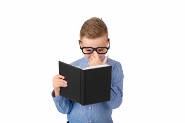 Şirin, hayalperest okul çocuğu kitap okuyor ve stüdyoda beyazların üzerinde tek başına dururken gözlük takıyor.