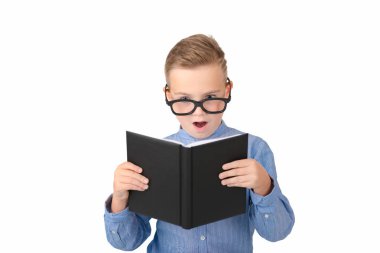 Ağzı açık liseli çocuk kitap okuyor ve stüdyoda beyazların üzerinde tek başına dururken gözlük takıyor.