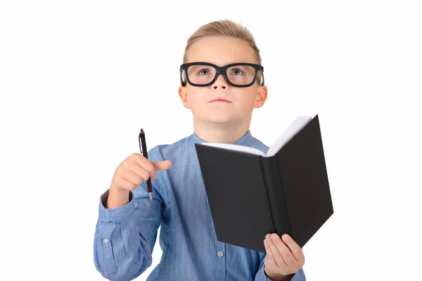 白い背景にノートのペンを手にした魅力的な白人の少年 眼鏡をかけた少年 子供は学校に行く準備ができています ストック画像