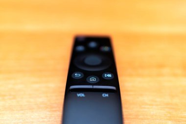 Masada modern bir TV uzaktan kumandası var. Üst görünüm, minimalizm