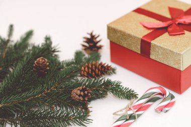 2021 Noel konsepti, hediye kutusu, dallar, köknar kozalakları ve baston şekerler beyaz arka planda.