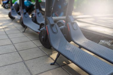 Elektrikli şehir ulaşımı: şehir merkezinde akümülatörlerle scooter sürmek için elektrik hazırlıkları sırası.