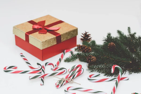 Christmas concept, new year concept. Gift Box, candy staff,candy canes Christmas tree branches. Fir tree branches,close up.Toned.White background.