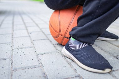 Üzgün ilkokul çocuğu vücudunun bir kısmı basketbola gömülmüş.