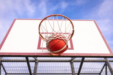 Basketbol tahtası mavi bulutlu gökyüzüne karşı basket potası.