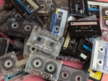 Üst görünüm düz Stack vintage birkaç kompakt kaset kaset seti pembe arka planda eski ses bantları.