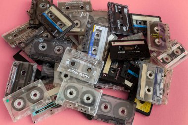 Üst görünüm düz Stack vintage birkaç kompakt kaset kaset seti pembe arka planda eski ses bantları.