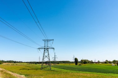 Mavi gökyüzüne karşı manzara çayırı ve güç hattı
