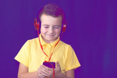 Kapat gözlerini, liseli çocuk telefonunu kullanıyor ve tek başına müzik dinliyor ya da video izliyor. Mor sisli arka plan..