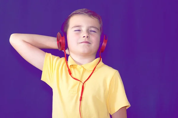 Закройте Закрытые Глаза Маленького Школьника Используя Свой Телефон Слушая Музыку — стоковое фото