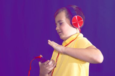 Genç bir öğrencinin telefonunu kullanıp tek başına müzik dinlemesi ya da video izlemesi. Mor sisli arka plan..