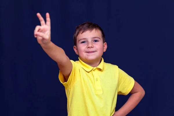 Chlapec Prsty Ukazuje Mír Nebo Vítězství Znamení Modrém Tmavém Pozadí — Stock fotografie