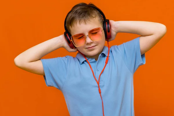 Garoto Atraente Vestindo Óculos Vermelhos Está Ouvindo Música Com Fones — Fotografia de Stock