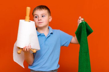 Beyaz bir çocuğun portresi. Oğlan kağıt havlu tutuyor, diğer el de havlu. Hangisi daha iyi. Ev Kadınları konsepti.