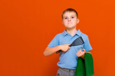 Turuncu arka planda profesyonel çocuk aşçı. Ev hanımları yeşil market konsepti..