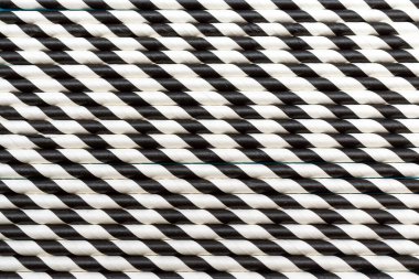 Bir sürü çizgili siyah beyaz tüp. Desen arkaplan düz mavi arkaplan