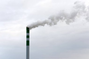 Stock Fotoğrafı: Büyük endüstriyel yeşil ve beyaz pipo. Dumanı dışarı çıkıyor. Zehirli duman atmosferi kirletir. çevresel sorunlar.