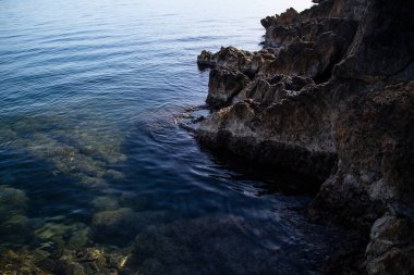 İspanya 'nın güzel gökyüzü ve kayalık kıyıları. Deniz yüzeyinin ve kayalık kıyıların bir fotoğrafı. Deniz kıyısında taşa vuran deniz dalgası. Okyanusun güzel manzarası.
