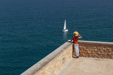 Balkonda deniz manzarasına bakan bir kadın. Deniz manzaralı teras. Sahilde düşünen bir kadın.. 