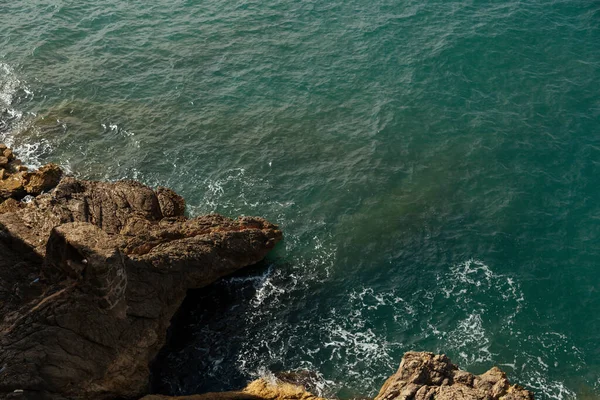 Eine Türkisfarbene Welle Rollt Auf Die Felsige Felsküste Als Die — Stockfoto