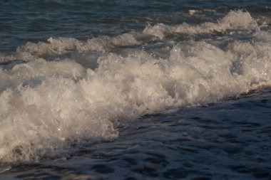Deniz dalgasının beyaz tepesi. Sahilde bir dalga..