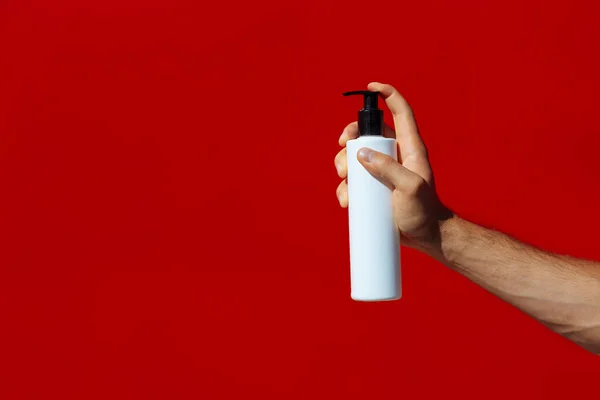 Hombre Sosteniendo Una Botella Blanca Aislada Sobre Fondo Rojo Hombre —  Fotos de Stock