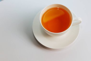 Fotokopi alanı olan bir fincan sıcak çayın en üst görüntüsü. Sıcak çay beyaz arka plana yerleştirilmiş beyaz bir bardaktadır. Mesaj için yer var. Beyaz arkaplan.