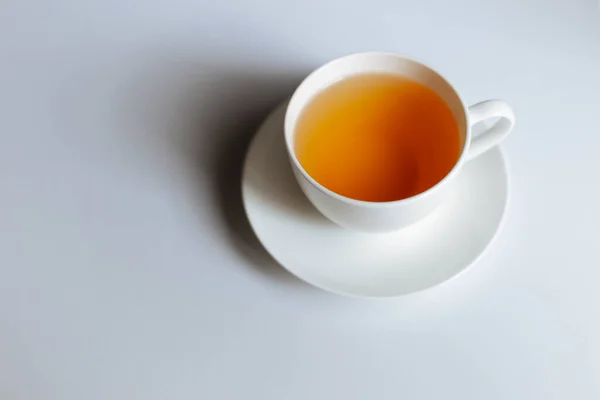 コピースペース付きの熱いお茶のカップのトップビュー 熱いお茶は白い背景に置かれた白いガラスの中にあります メッセージのためのスペースがあります — ストック写真