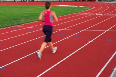 Spor. Atletik genç kadın spor ayakkabı koşu parkuru stadyum üzerinde çalıştırın. Koşmak kavramı. 