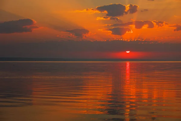 Dramatic sunset sky with clouds over lake. Composition of nature