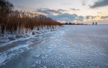 Güzel kış manzara günbatımı gökyüzü dondurulmuş rezervuar ve santral ile