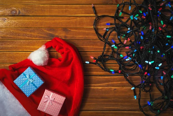 Luces Coloridas Vacaciones Guirnalda Sombrero Santa Claus Cajas Regalo Fondo — Foto de Stock