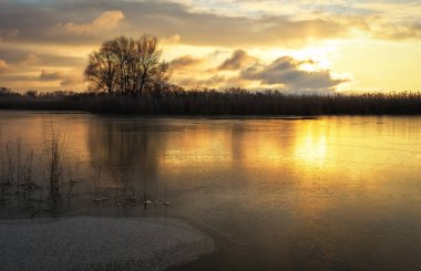 Donmuş nehir ve günbatımı gökyüzü, kış yatay. Doğanın kompozisyon.