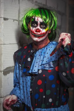 Çılgın palyaço bir tuğla duvar arka planda bir bıçakla. Cadılar Bayramı kavramı