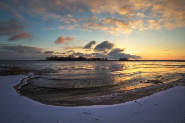 Donmuş göl ve günbatımı gökyüzü, kış yatay. Turuncu renkli gökyüzü. Doğanın kompozisyon