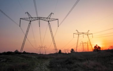 Ateşli gündoğumu sırasında yüksek voltajlı elektrik hatları