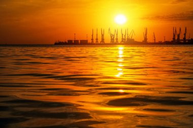 Ateşli gün batımı gökyüzü ve deniz ile güzel manzara. Liman üzerinde