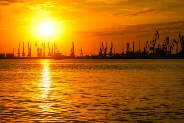 Ateşli gün batımı gökyüzü ve deniz ile güzel manzara. Liman üzerinde