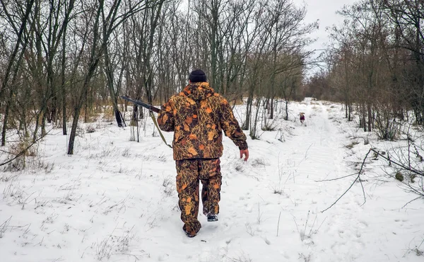 Winterjagd. Jäger bewegt sich mit Gewehr auf der Suche nach Beute. — Stockfoto