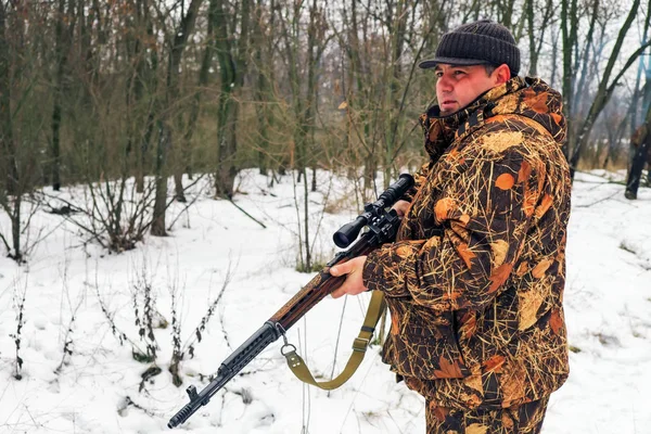 Zimowe polowanie. Hunter rusza się ze strzelbą i szuka ofiary.. — Zdjęcie stockowe