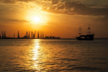 Ateşli gün batımı gökyüzü ve deniz ile güzel manzara. Liman üzerinde