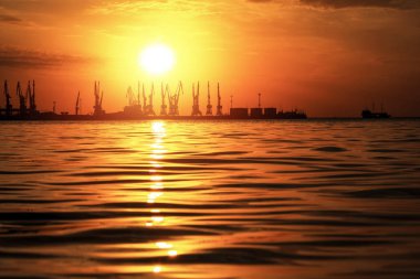 Ateşli gün batımı gökyüzü ve deniz ile güzel manzara. Liman üzerinde