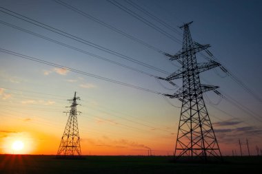 Siluet Gün batımında yüksek gerilim elektrik kuleleri. Yüksek vol