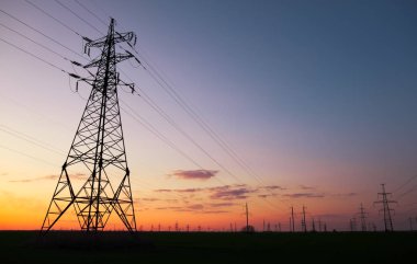 Siluet Gün batımında yüksek gerilim elektrik kuleleri. Yüksek vol