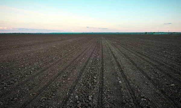 Preparing field for planting. Plowed soil  in spring time with b — Stock Photo, Image