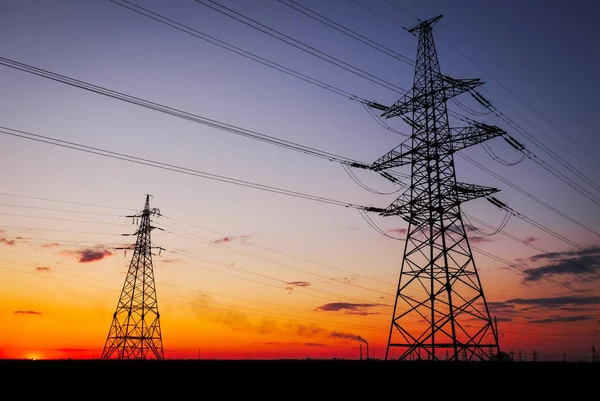 Silhouette High voltage electric towers at sunset time. High-vol — Stock Photo, Image
