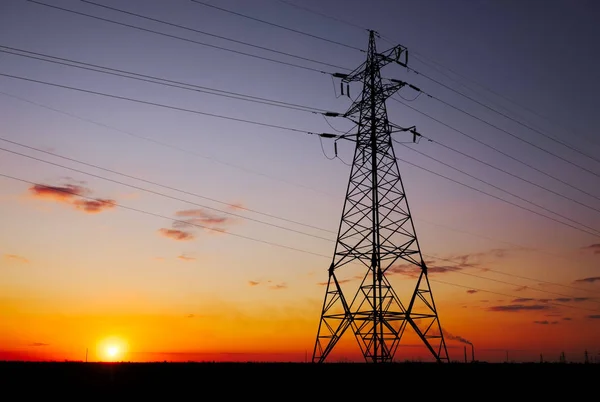 Silhouette High voltage electric towers at sunset time. High-vol — Stock Photo, Image